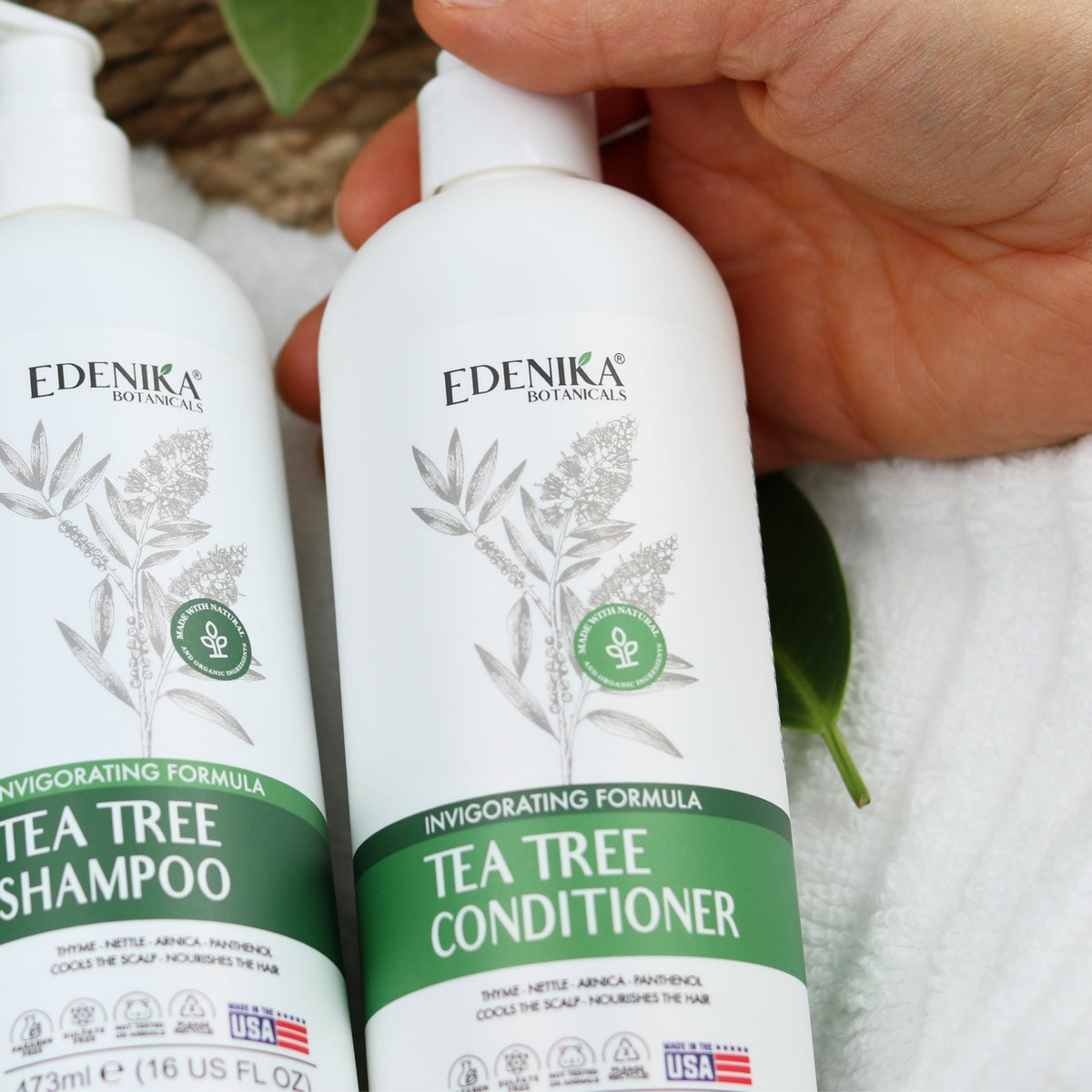 Edenika Tea Tree shampoo and conditioner with fresh greenery and towels